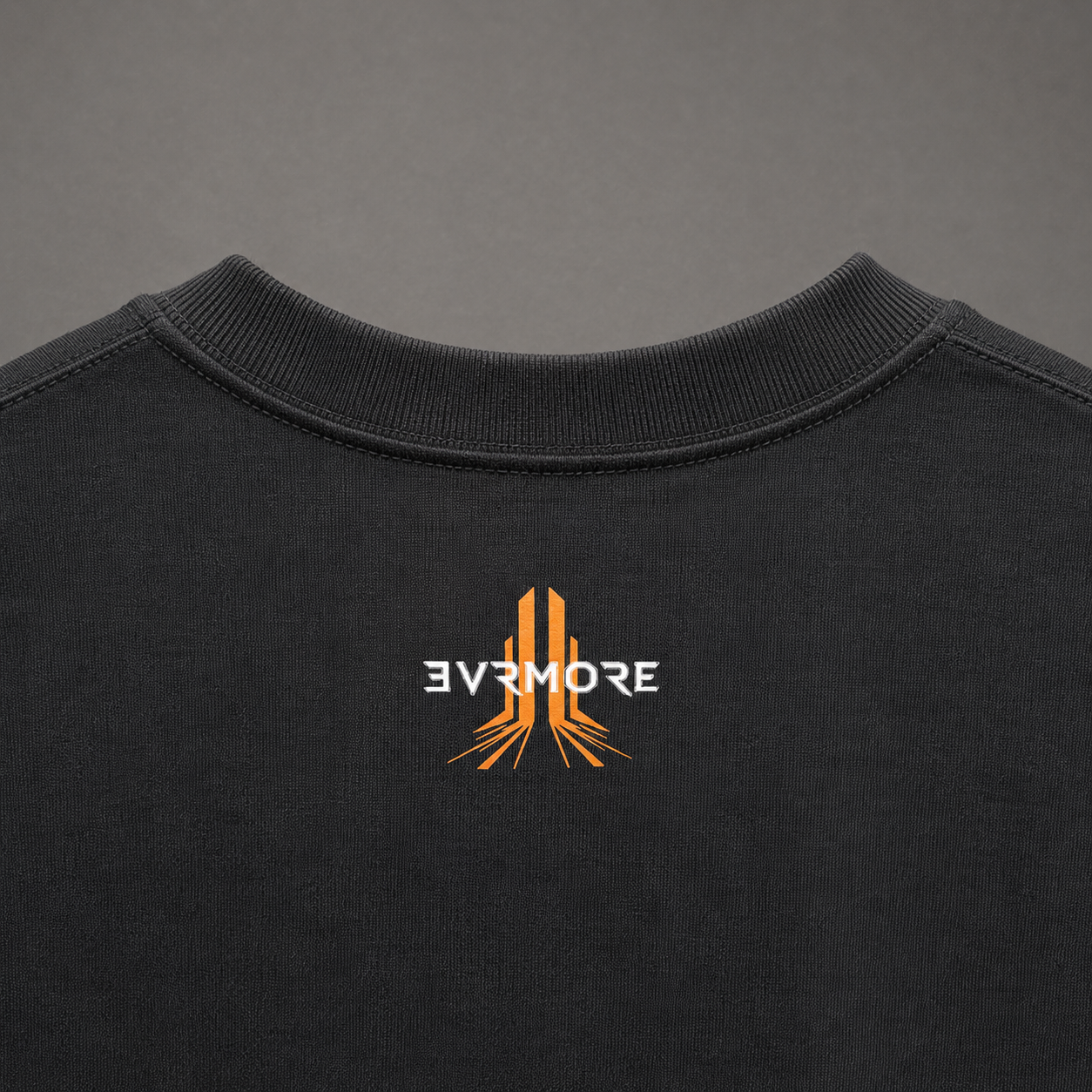 Close-up of the back of a black crewneck sweatshirt featuring an orange and white 'EVRMORE' logo printed on the center.