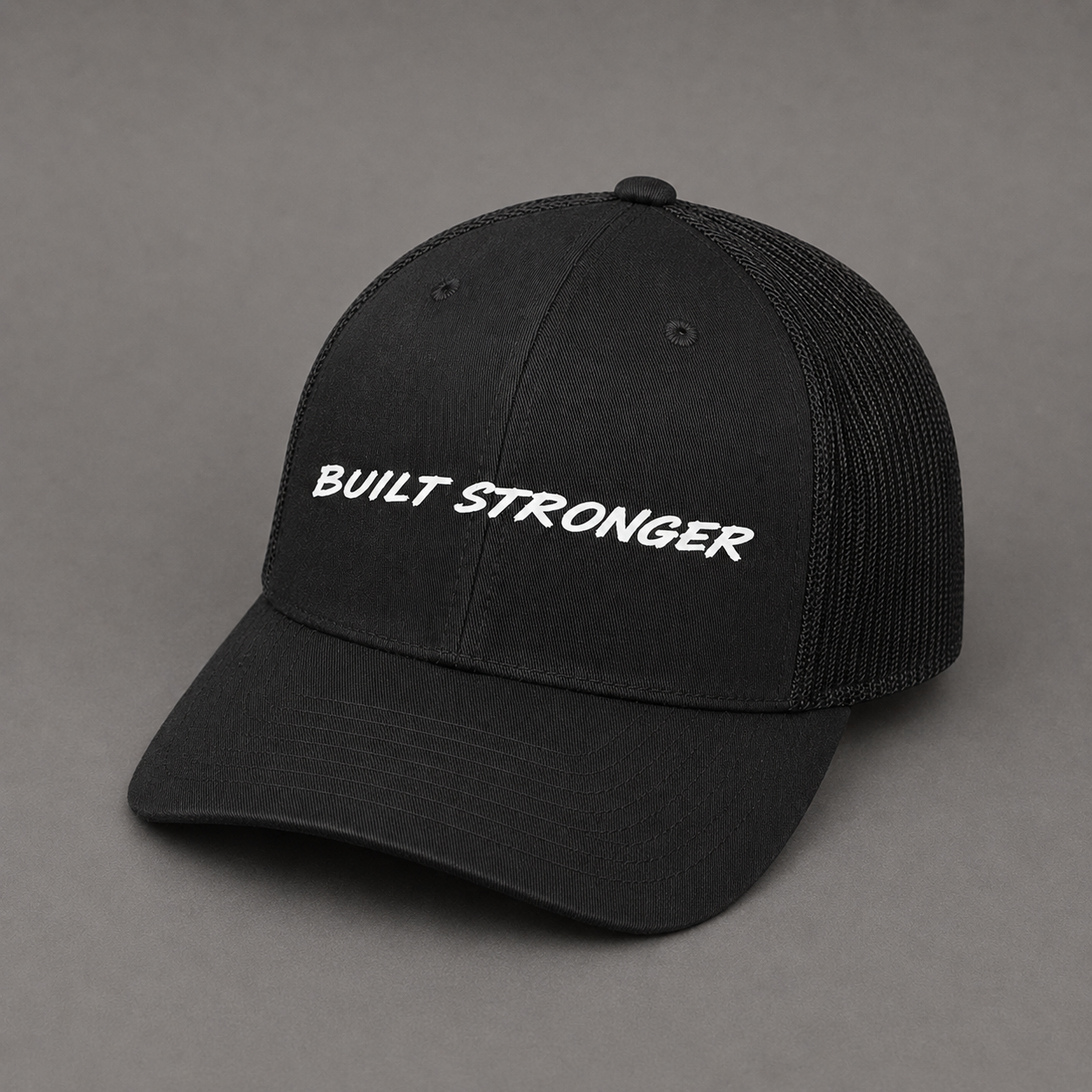 A black trucker-style baseball cap with white embroidered text reading 'BUILT STRONGER' on the front, shown against a plain gray background.