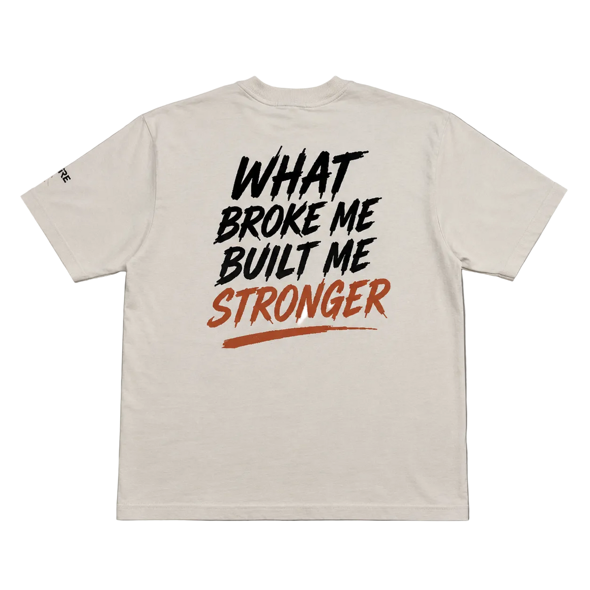 An off-white short-sleeve t-shirt laid flat on a gray background, featuring a graphic print on the back with the text 'WHAT BROKE ME BUILT ME STRONGER' in black and orange-red lettering.